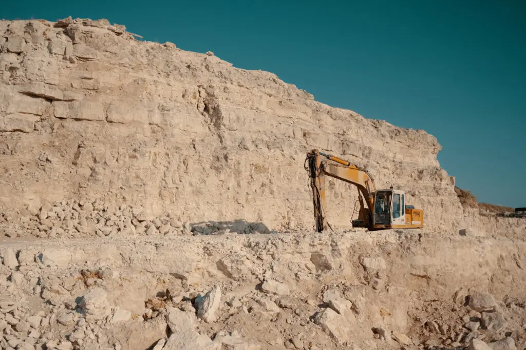 Excavator performing rock quarry and excavation work